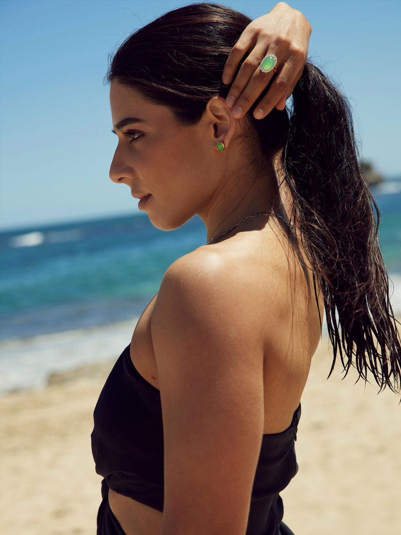 Woman at the beach wearing a jade ring and jade earrings